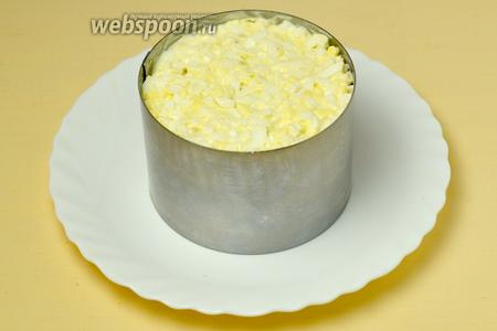 Укладываем салат слоями в кольцо: яйца, ананас, крабовые палочки, сыр, кукуруза и снова яйца.