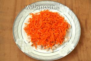 Сверху курицы выложить слой корейской моркови, который смазывать не нужно.