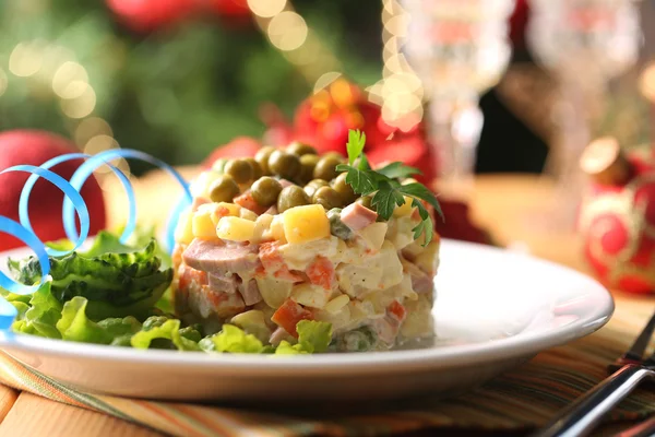 Российский традиционный салат olivier, на цветной салфетке, на деревянном столе, на ярком фоне — стоковое фото