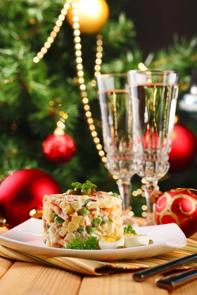Российский традиционный салат olivier, на цветной салфетке, на деревянном столе, на ярком фоне — стоковое фото